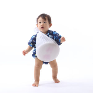 一升餅を担いで歩く男の子