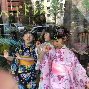 ガラスのウィンドーに楽しく落書きするこどもたち